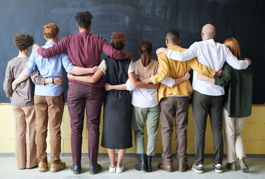 people embracing in front of a chalkboard